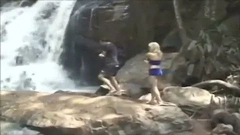 couple Rests By A Waterfall