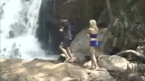 couple Rests By A Waterfall